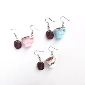 Coffee bean and cup drop earrings in ivory, pastel blue, and blush pink.