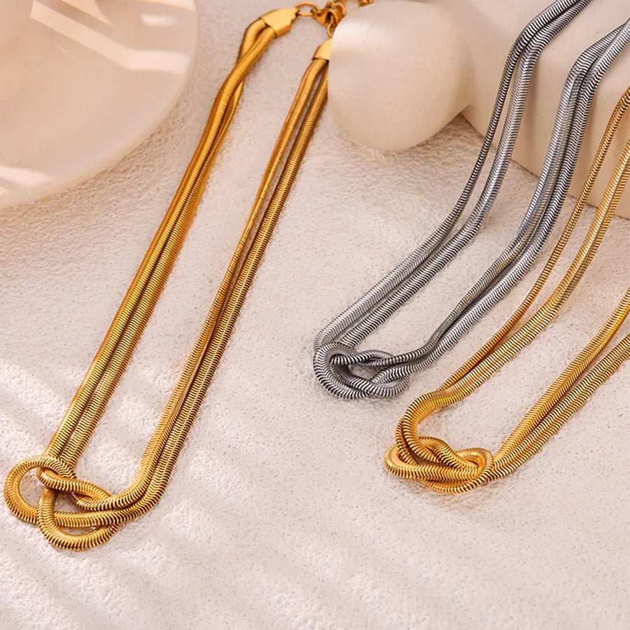 Gold and silver serpent necklaces with knot detail