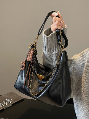 crossbody bag in black featuring chain detail and slouchy fit