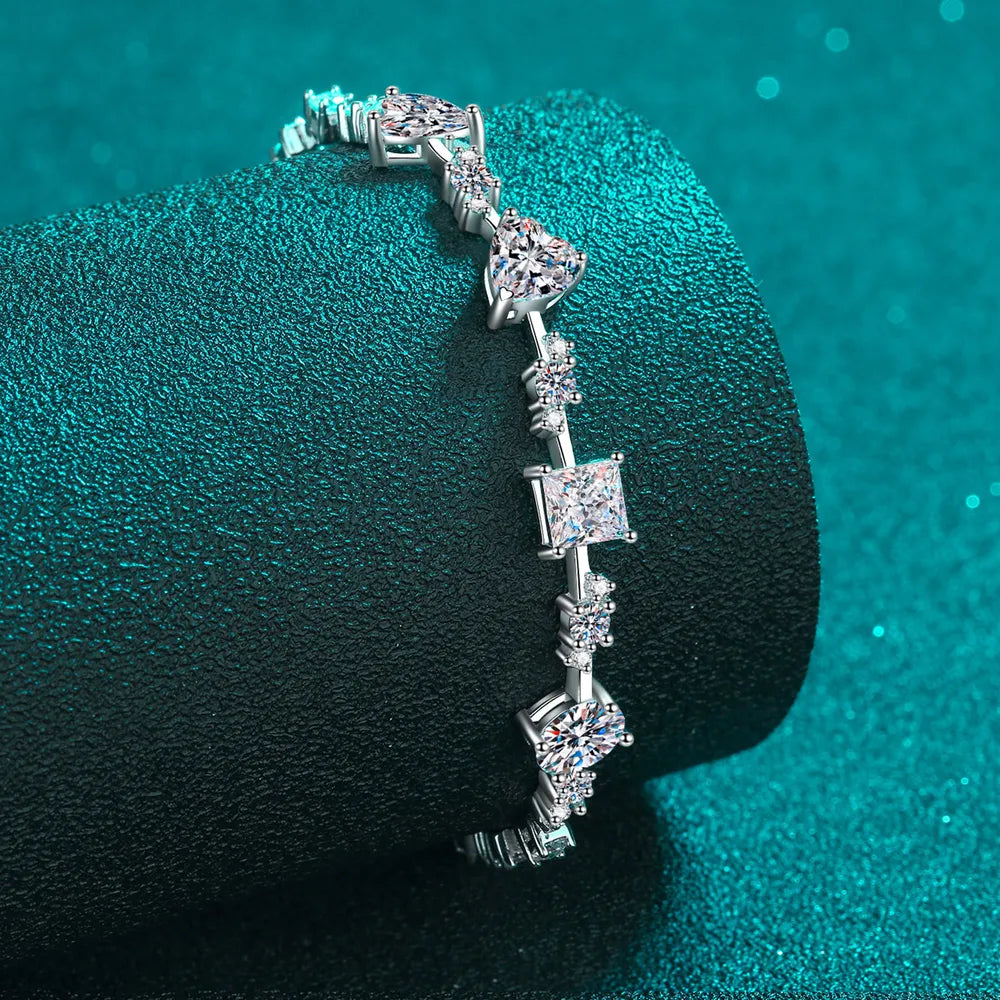 Silver moissanite bracelet with geometric and heart-shaped stones.