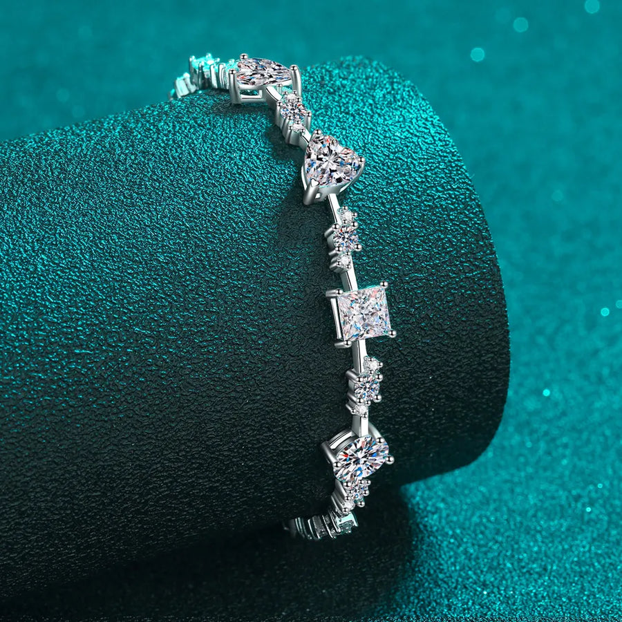 Silver moissanite bracelet with geometric and heart-shaped stones.