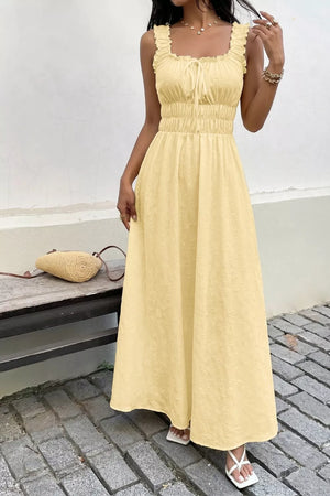 Yellow smocked floral maxi dress with frill straps and tie-front neckline.