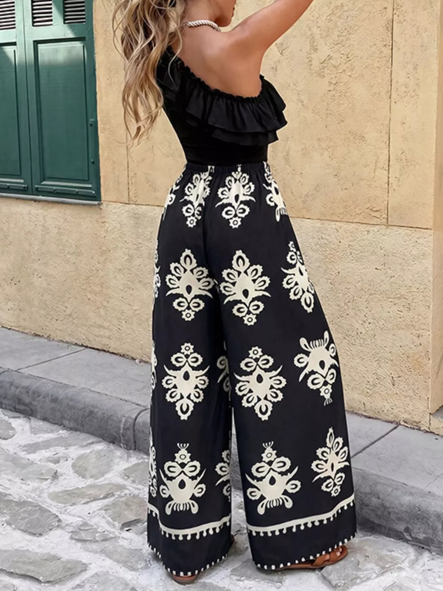 Black one-shoulder ruffled crop top with black and white printed wide-leg pants.