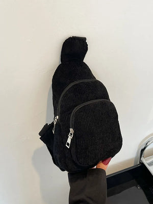 Black corduroy sling bag with zip pockets and adjustable strap