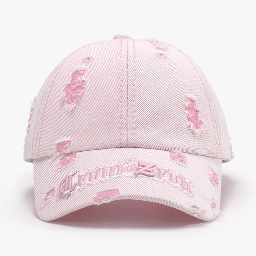 Blush pink distressed baseball cap with embroidered text and frayed details.
