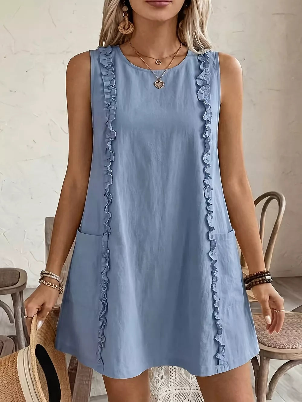 Light blue sleeveless dress with frill details and pockets.