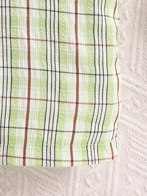 Children's green plaid overalls with adjustable straps detail