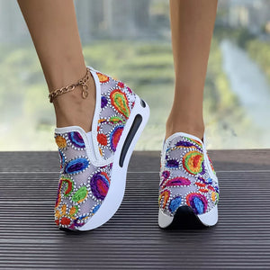 Paisley print platform slip-on shoes with a chunky white sole and colorful embroidery.