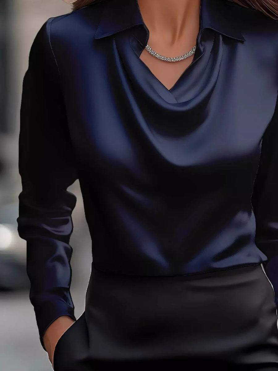 Dark blue satin cowl neck long-sleeve blouse with a collar and a necklace.