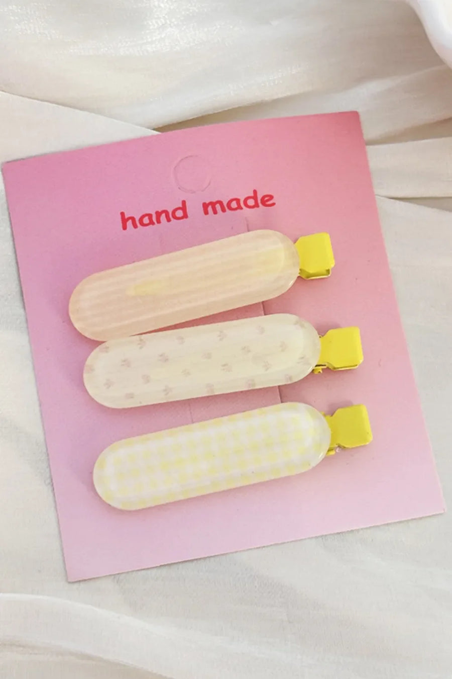 Pastel patterned hair clips trio with yellow clasps, including stripes, dots, and gingham.