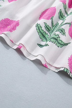 Vibrant floral ruffle mini dress with pink floral print on white fabric, showing ruffled hem detail.