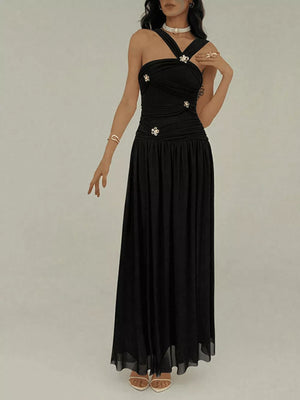 Black ruched sleeveless maxi dress with embellished halter neckline and flowy skirt.