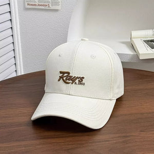 White baseball cap with embroidered "Ray's E. 1958" detail