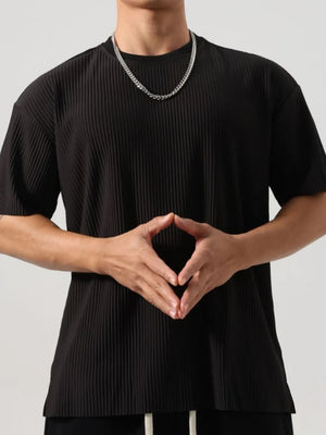 Black oversized tee with sculpted vertical pleats and crew neck.