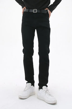 Black slim-fit stretch denim trousers with a black belt.