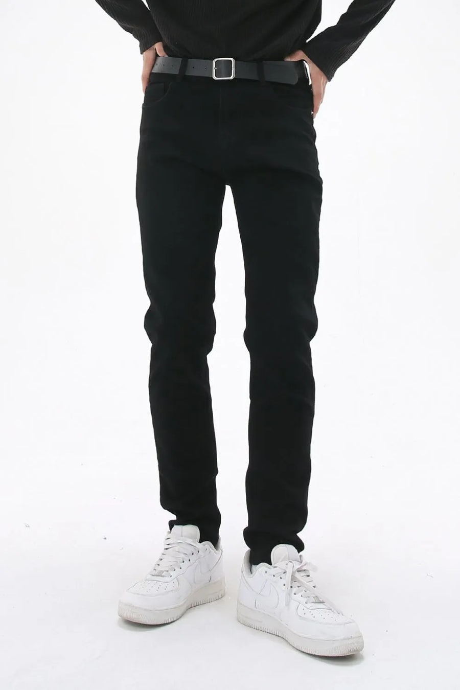 Black slim-fit stretch denim trousers with a black belt.