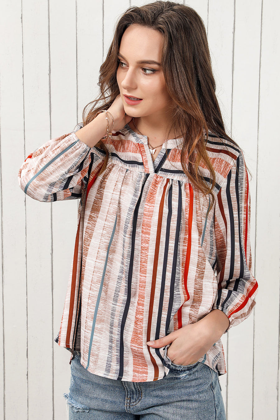 Vertical stripe gathered yoke blouse with v-neck and long sleeves.
