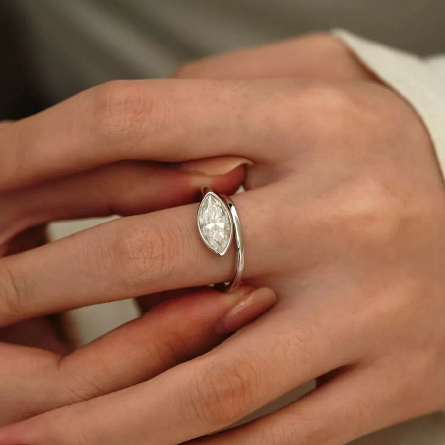 Elegant marquise moissanite bypass ring in silver with a single clear stone.