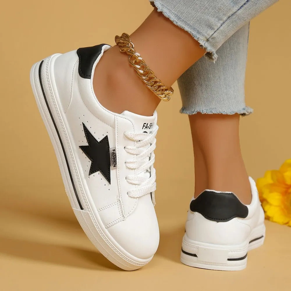 White sneakers with black star patch and black heel detail.