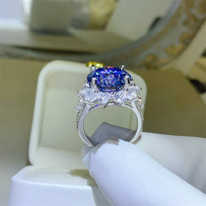 Dark blue moissanite cocktail ring in sterling silver with halo of white stones