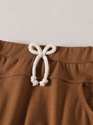 Light brown baby set shorts with drawstring waist and pocket detail.