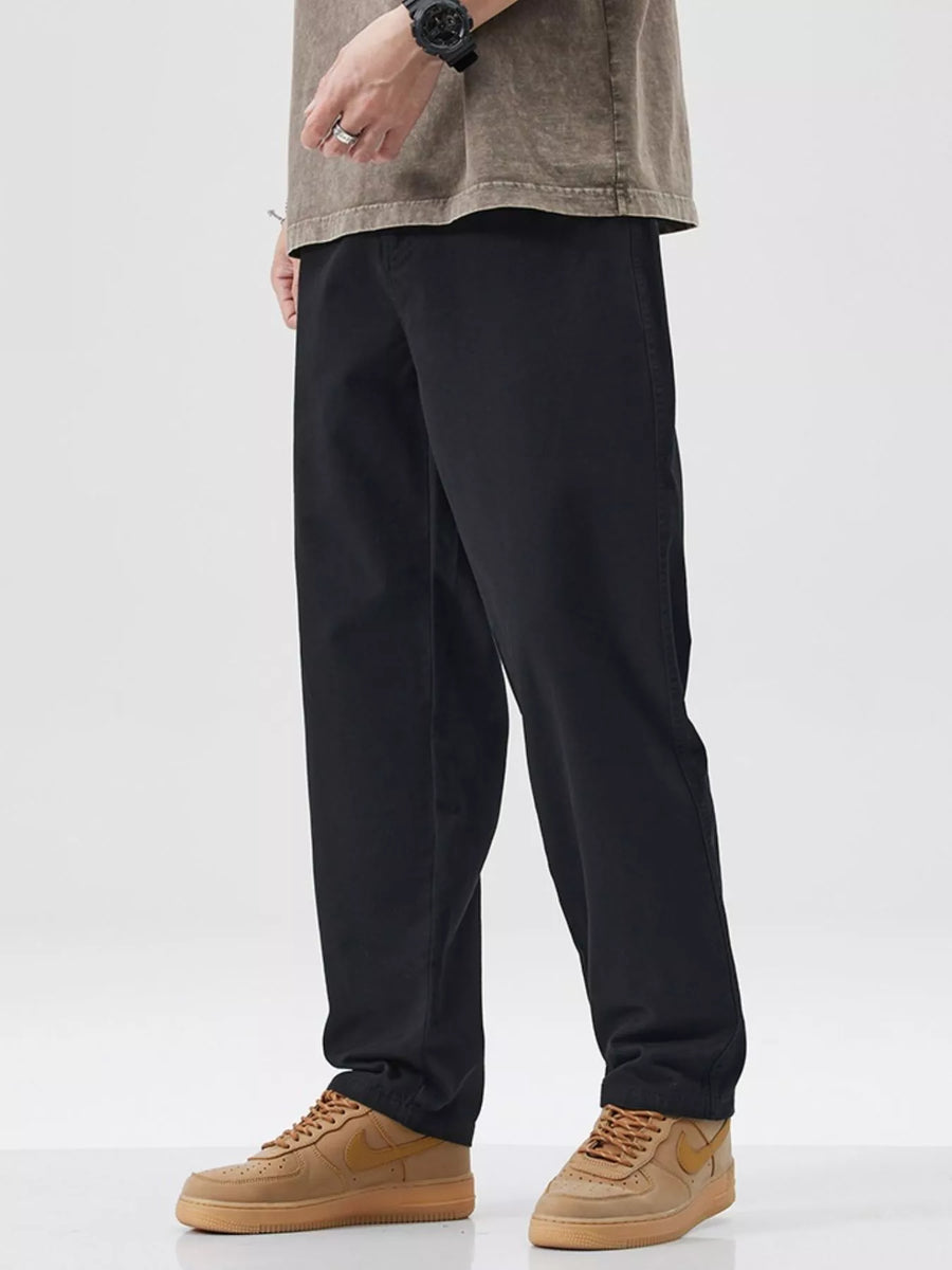Black cotton pants with a relaxed fit, styled with a t-shirt and sneakers.
