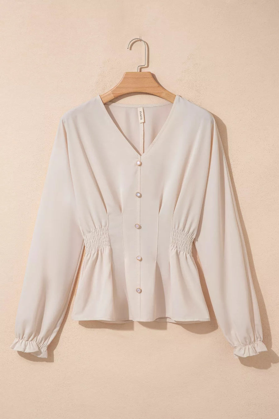 Elegant V-neck polyester blouse with smocked waist and button front in cream.