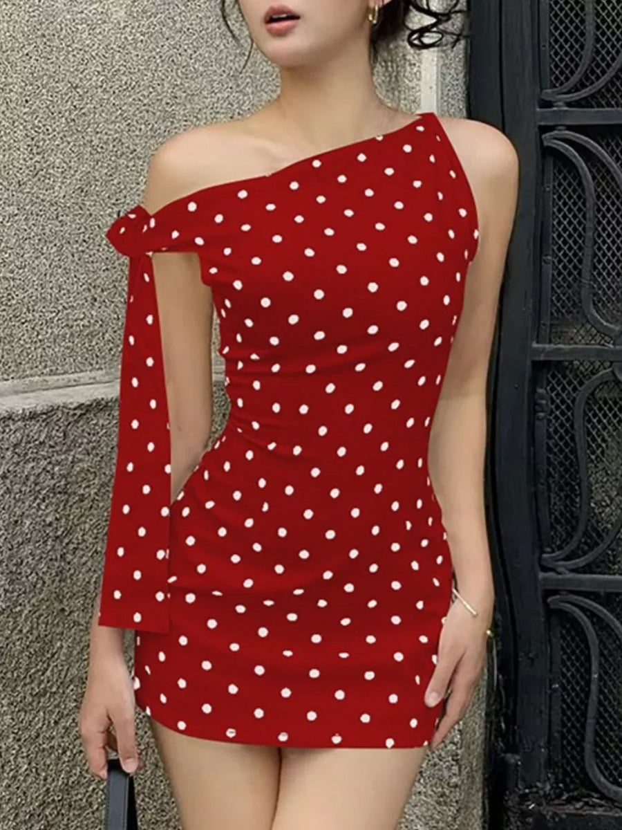 Red polka dot mini dress with asymmetrical neckline and bow detail