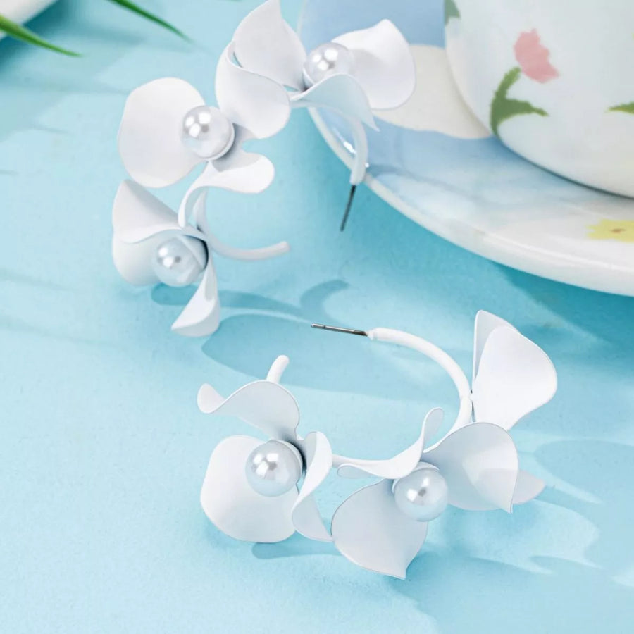 White floral pearl hoop earrings with delicate petals and faux pearls.