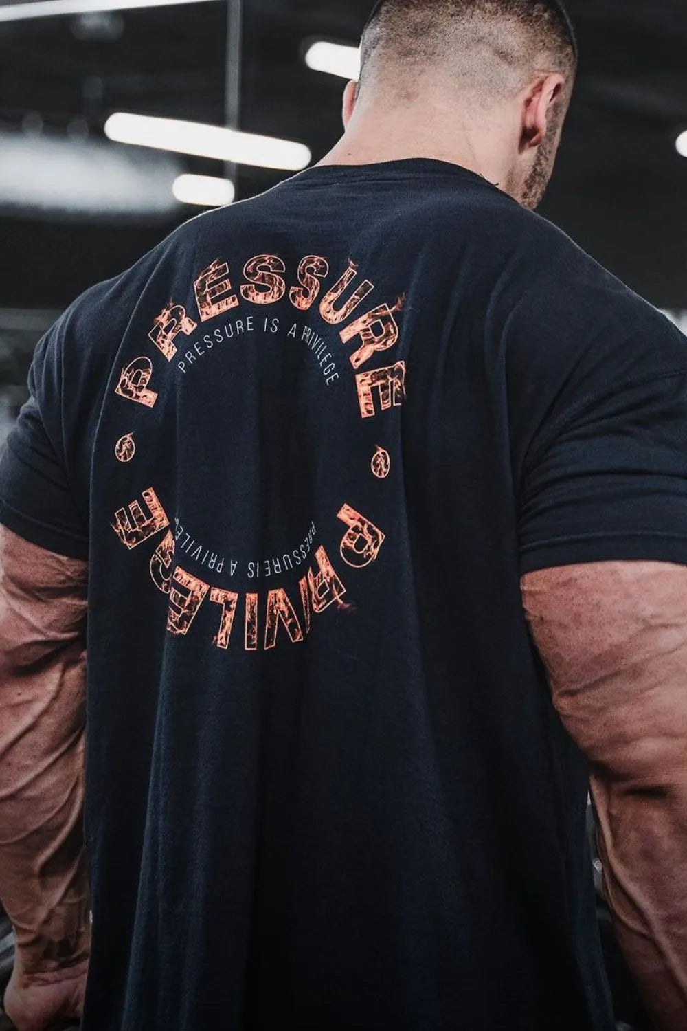 Black graphic t-shirt with circular "Pressure Privilege" text and distressed font detail.