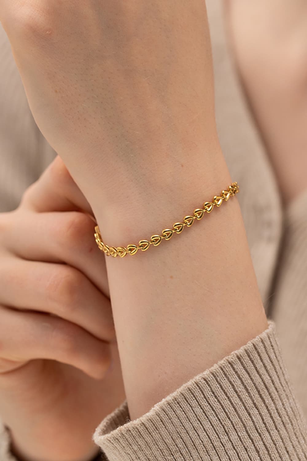 Gold linked heartbeat chain bracelet with delicate heart details.