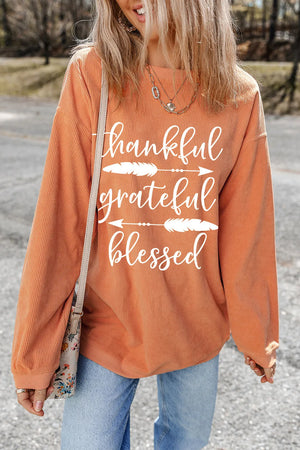 Corduroy crewneck sweatshirt in sherbet with white graphic text and feather accents.