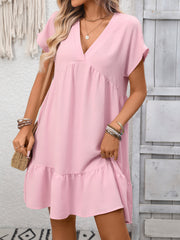 Pink V-neck mini dress with short sleeves and ruffled hem, featuring a tiered silhouette.