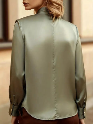 Olive satin blouse with long sleeves and button cuffs, showing back detail.