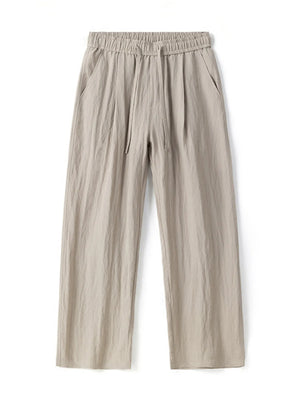 Lightweight khaki wide-leg trousers with drawstring waist and pockets.