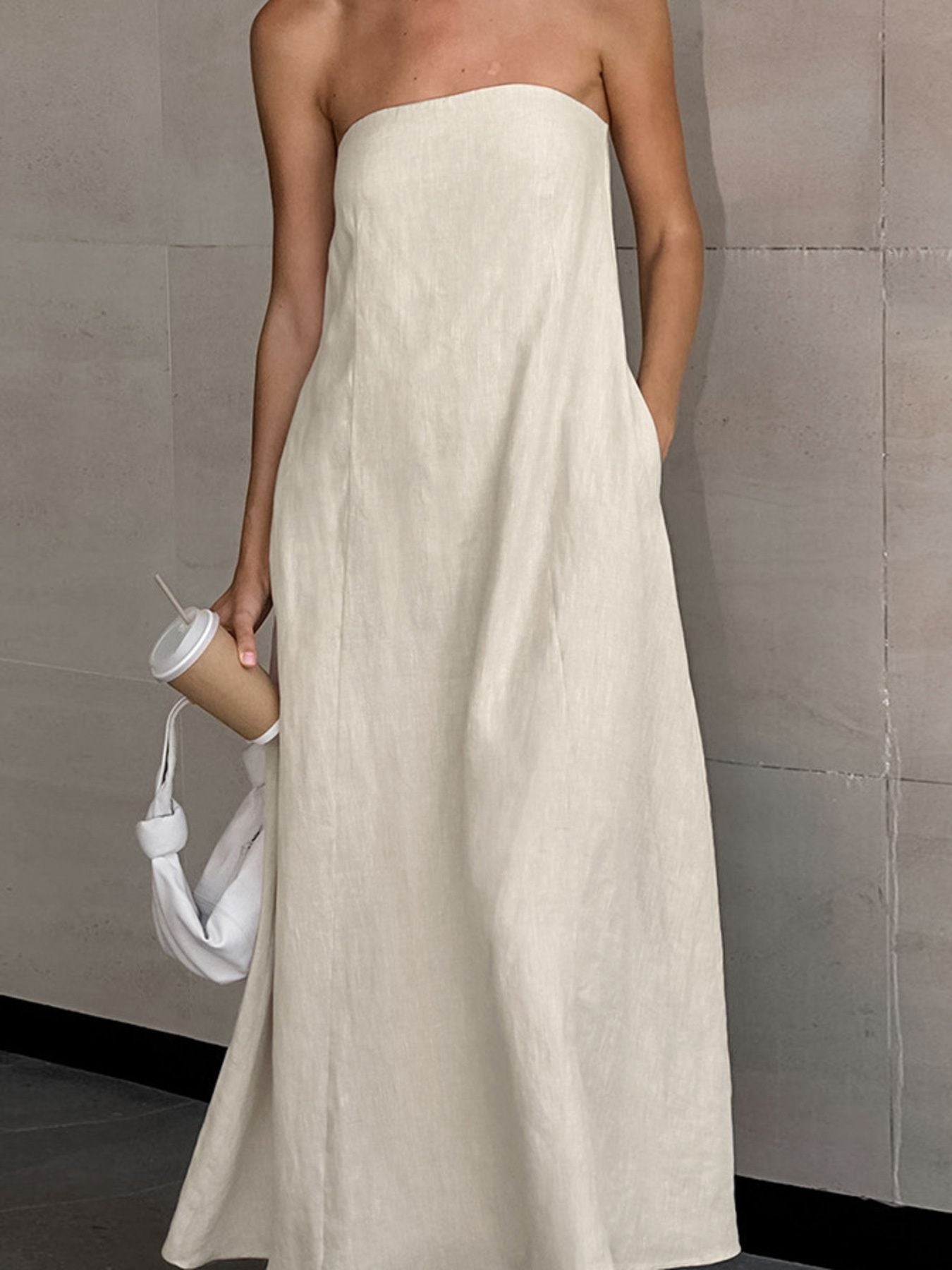 Beige smocked tube dress in cotton with a zipper and pockets.