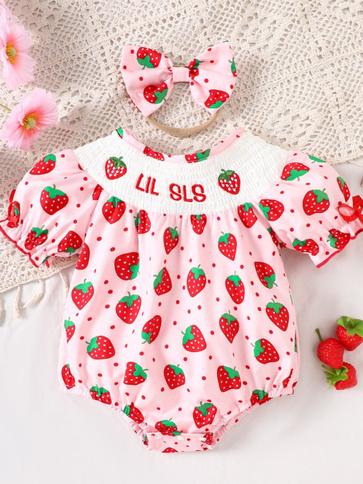 Baby pink cotton smocked one-piece with strawberry print and bow headband.