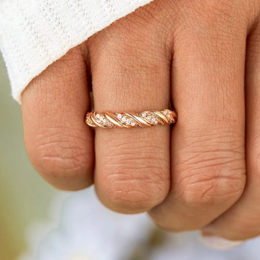 Gold twisted band ring with cubic zirconia accents on sterling silver.