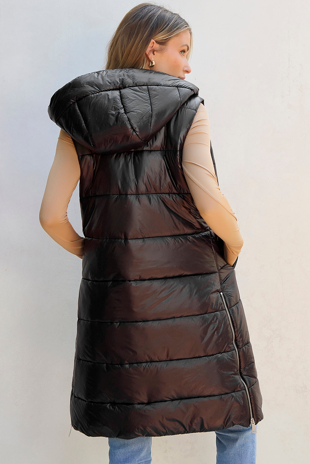 Longline hooded puffer vest in black with quilted detailing and a zipper closure.