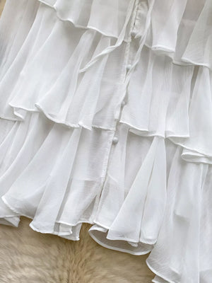 White chiffon tiered blouse with ruffled details and button front.