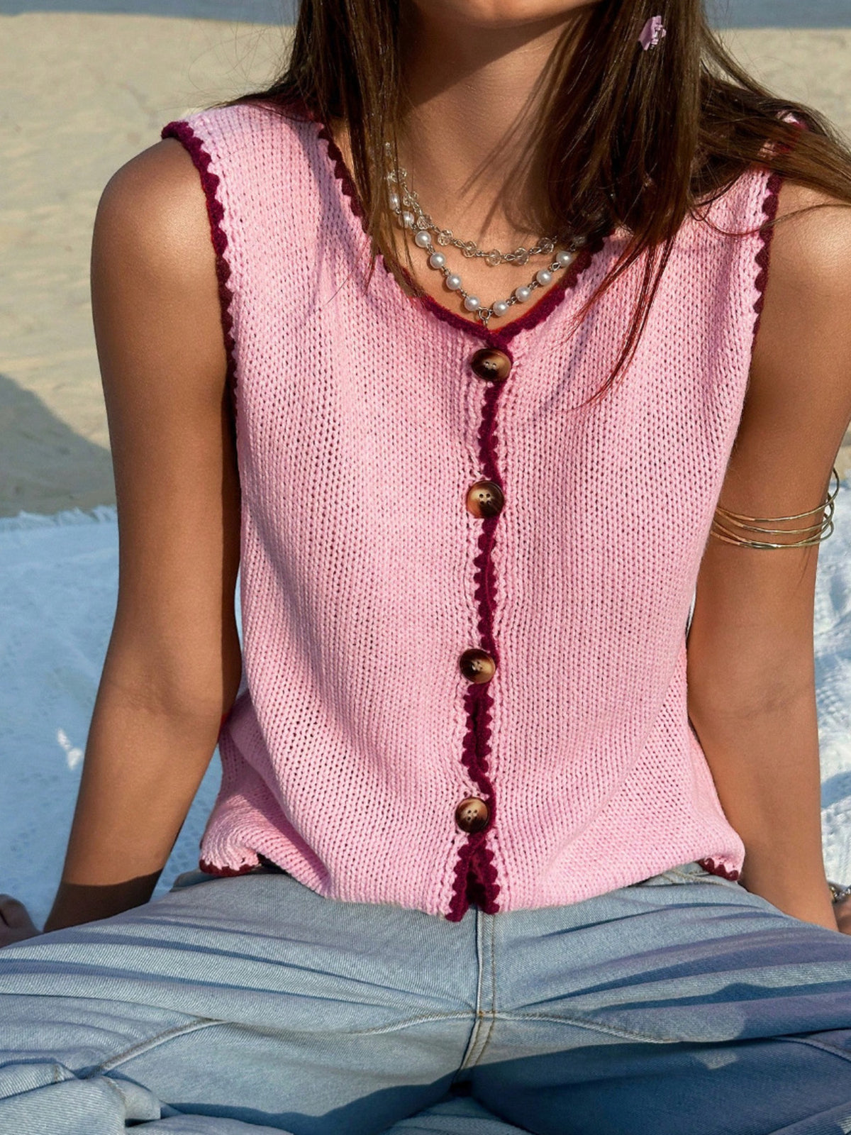 Pink knit sweater vest with button front and contrast trim