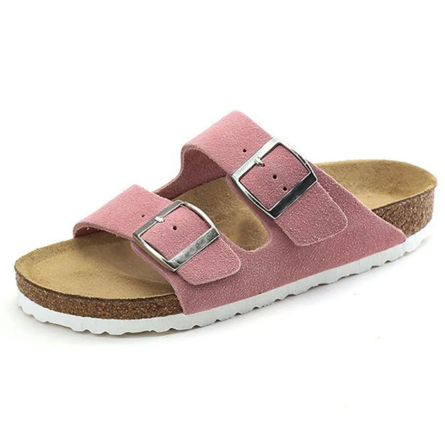 Pink suede slide sandals with double adjustable buckle straps and cork footbed.