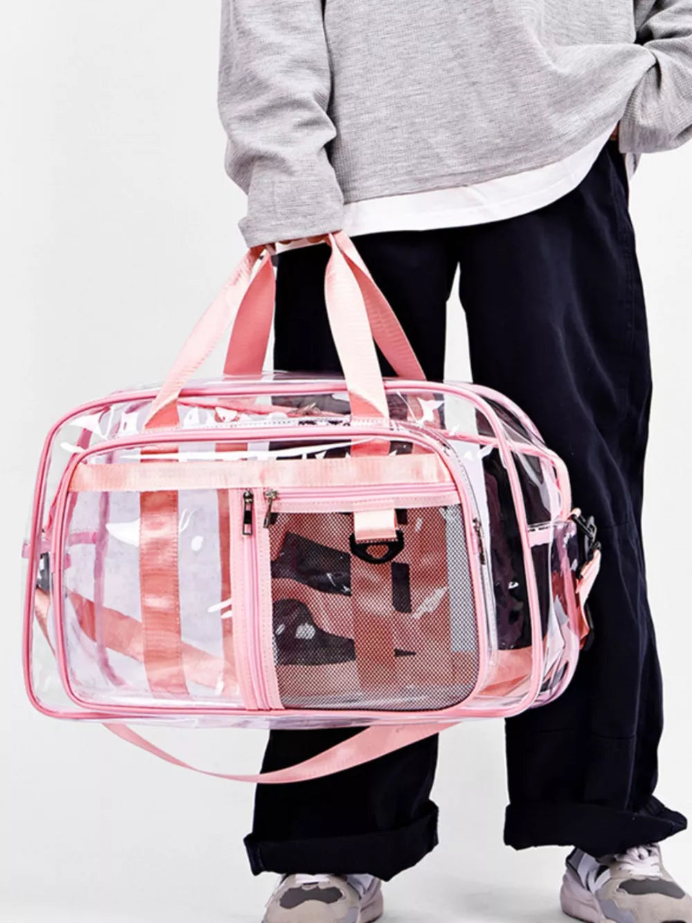 Clear duffel bag with pink stripes and mesh pockets, pink straps and trim