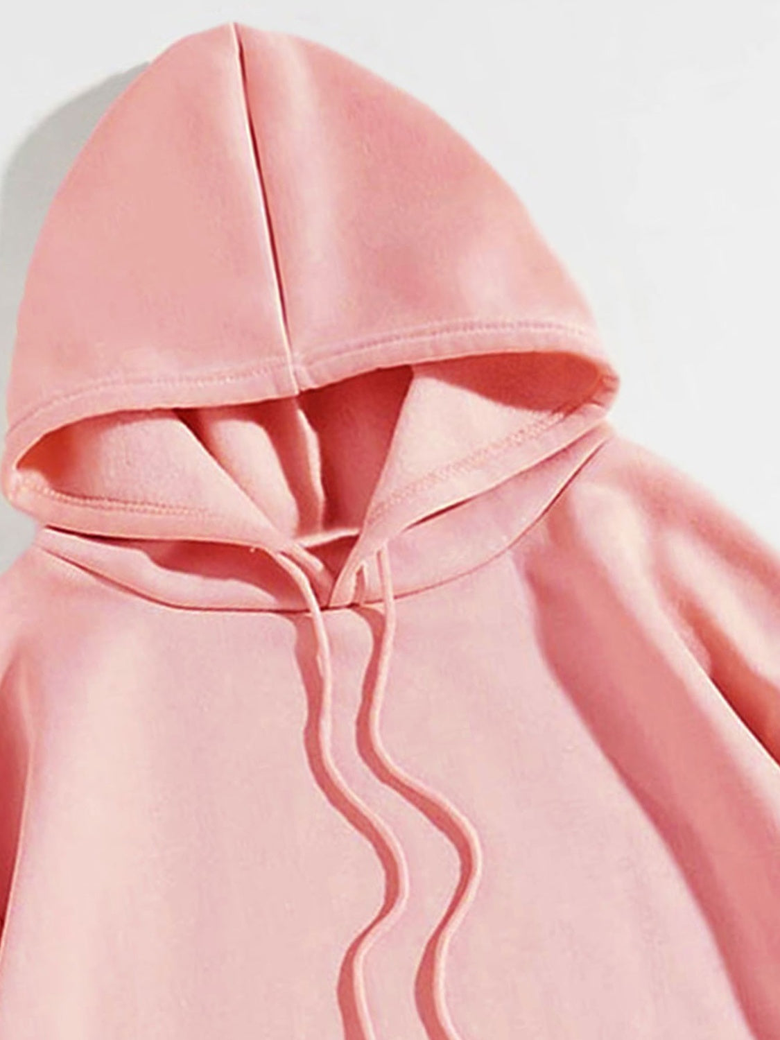 Blush pink hoodie with adjustable drawstring hood and acrylic fabric.