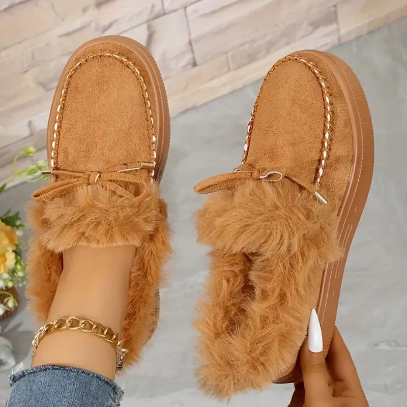 Brown suede loafers with shearling trim and bow detail.
