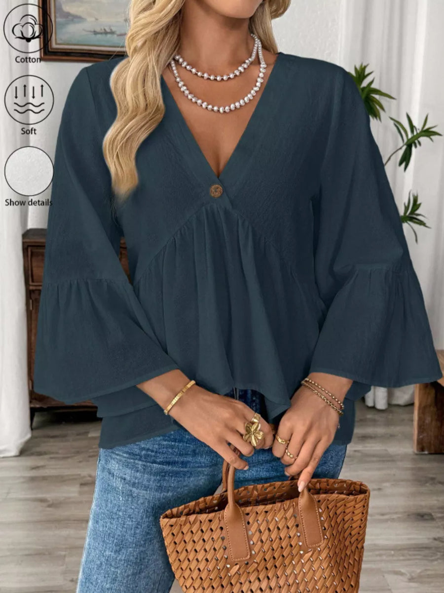 Navy blue cotton V-neck blouse with bell sleeves and a single button detail.