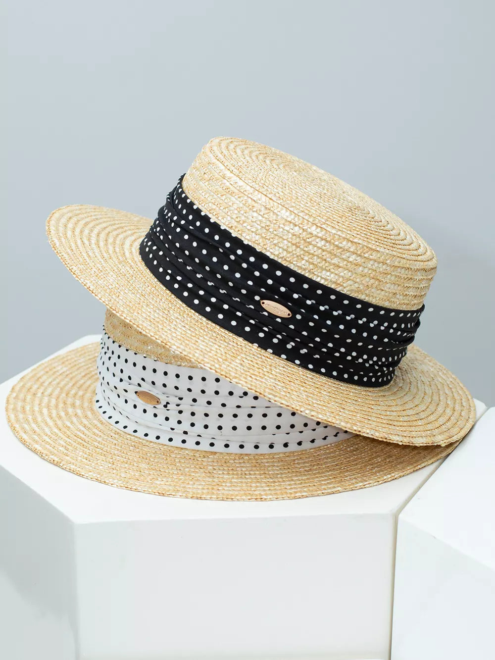 Wheat straw boater hat with ruched ribbon detail and polka dot pattern.