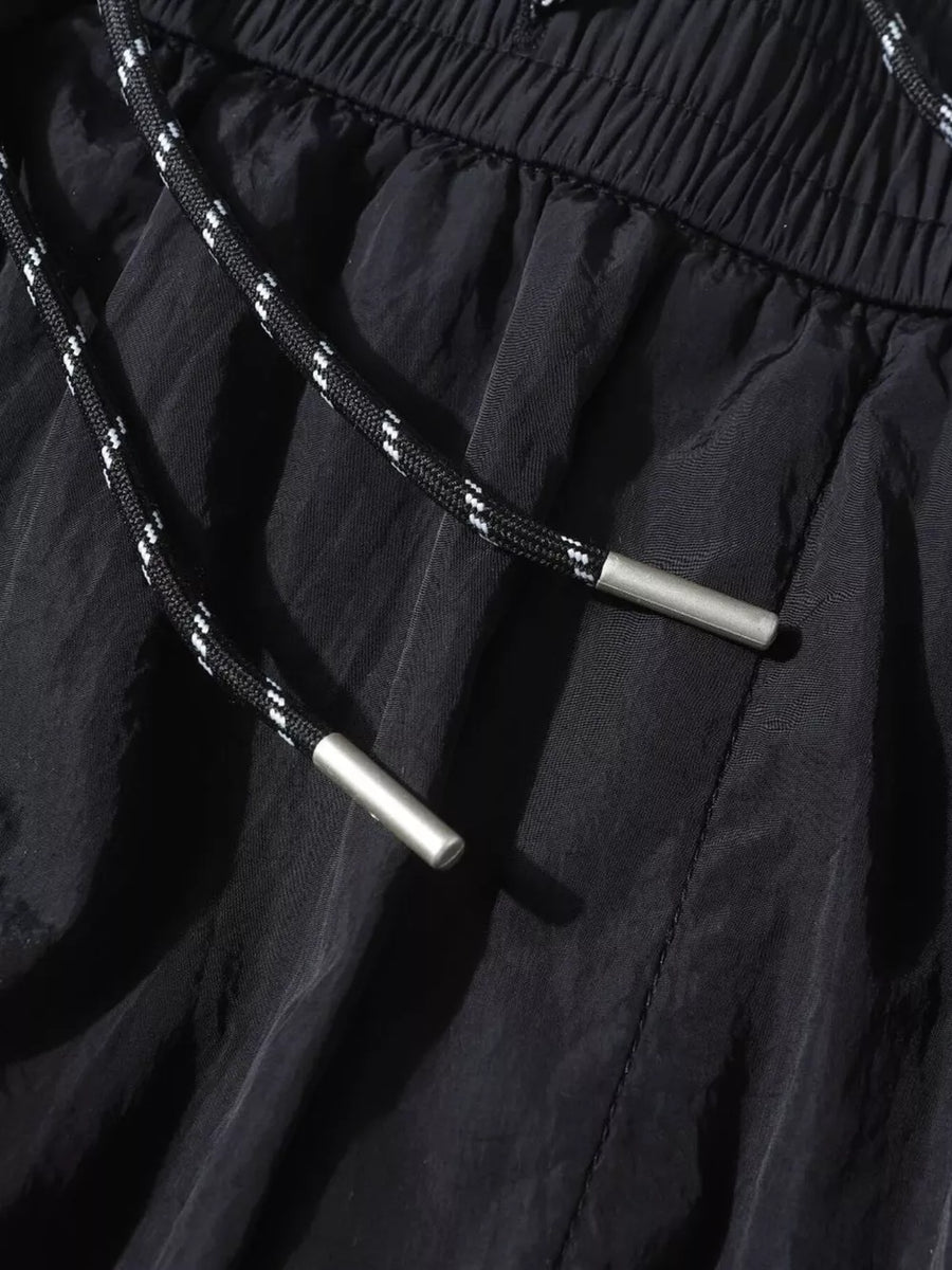 Black wide-leg cargo pants with drawstring and metal tips, elastic waistband.