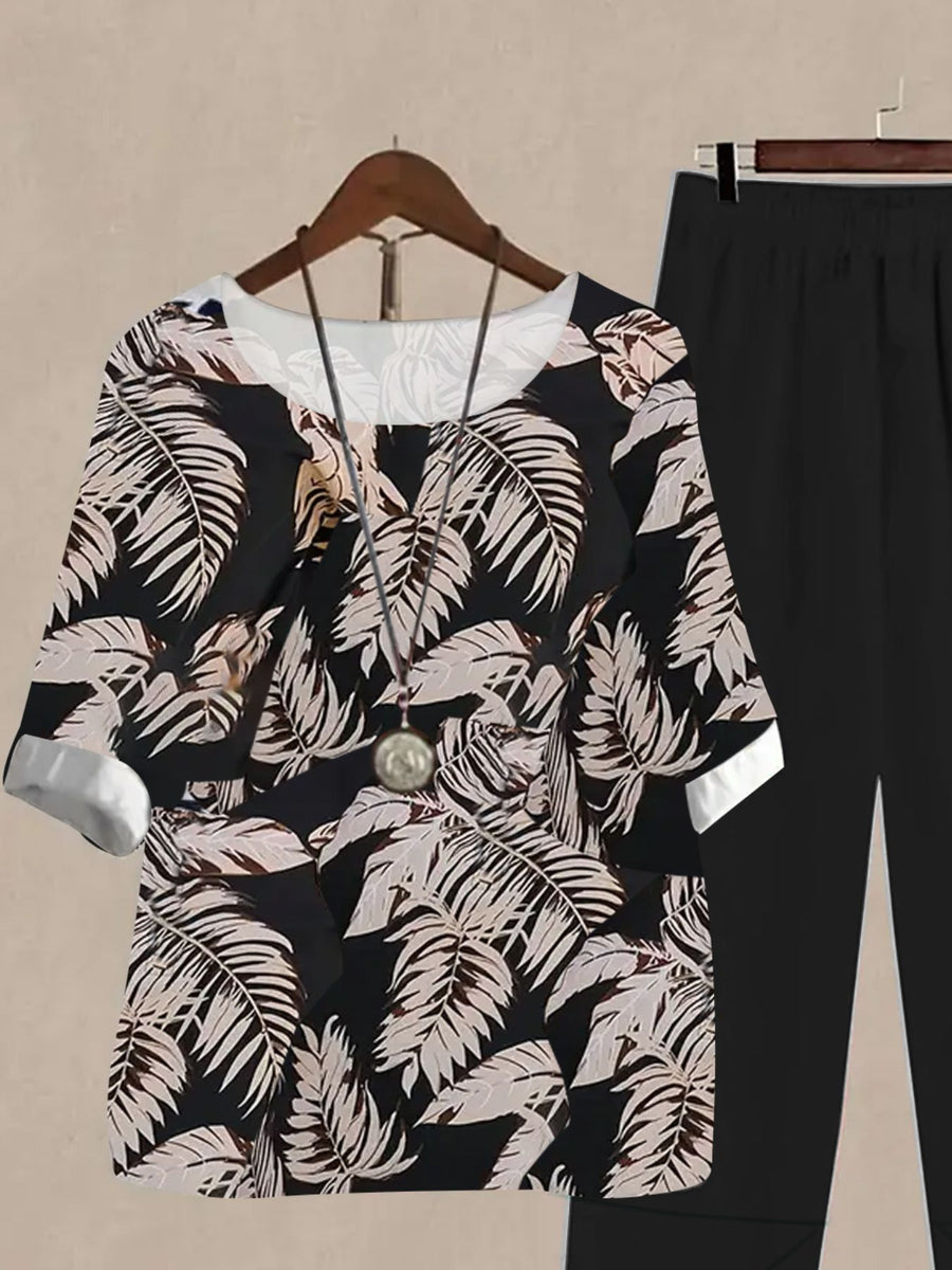 Floral print half sleeve top and black pants set with white cuffs and neckline.