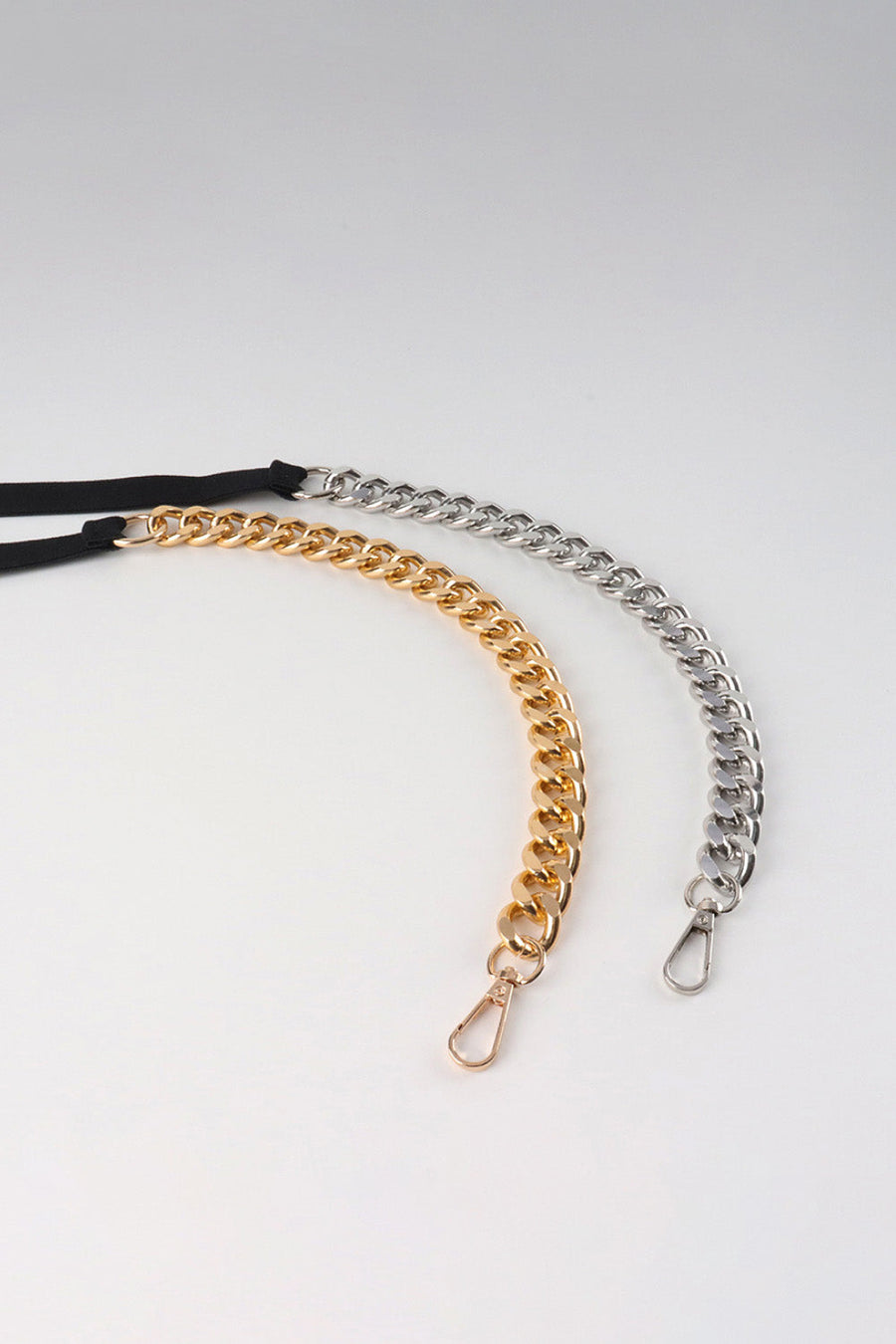 Chain detail elastic waist belt with gold and silver curb chains and black elastic band.